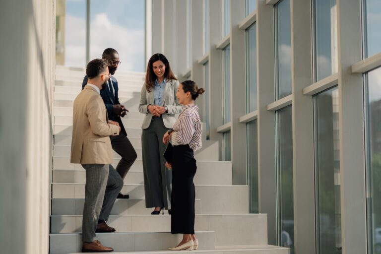 Business professionals discussing leadership strategy in passing on the stairs in a modern office